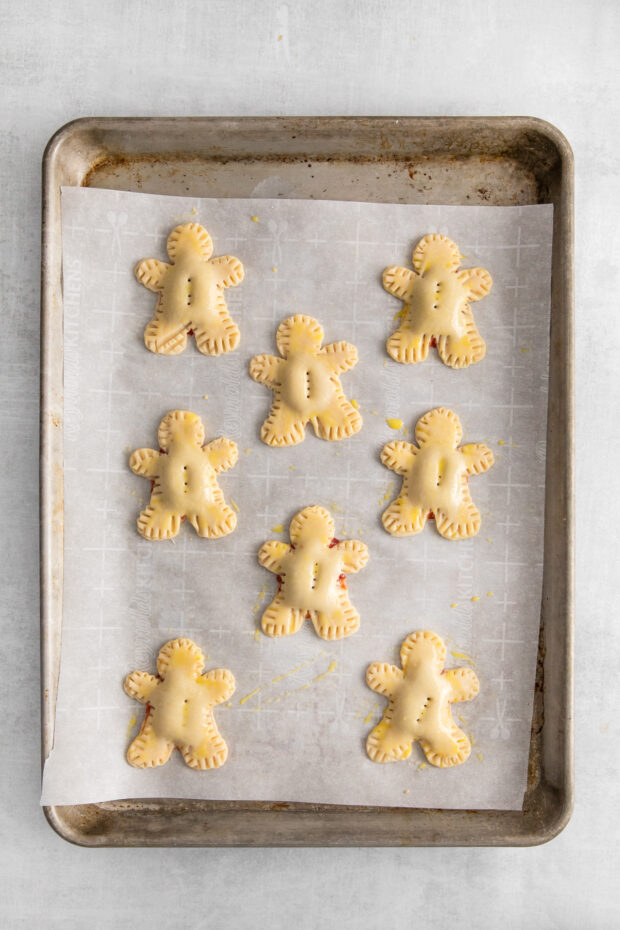 Mummy Hand Pies on parchment paper waiting to baked. 