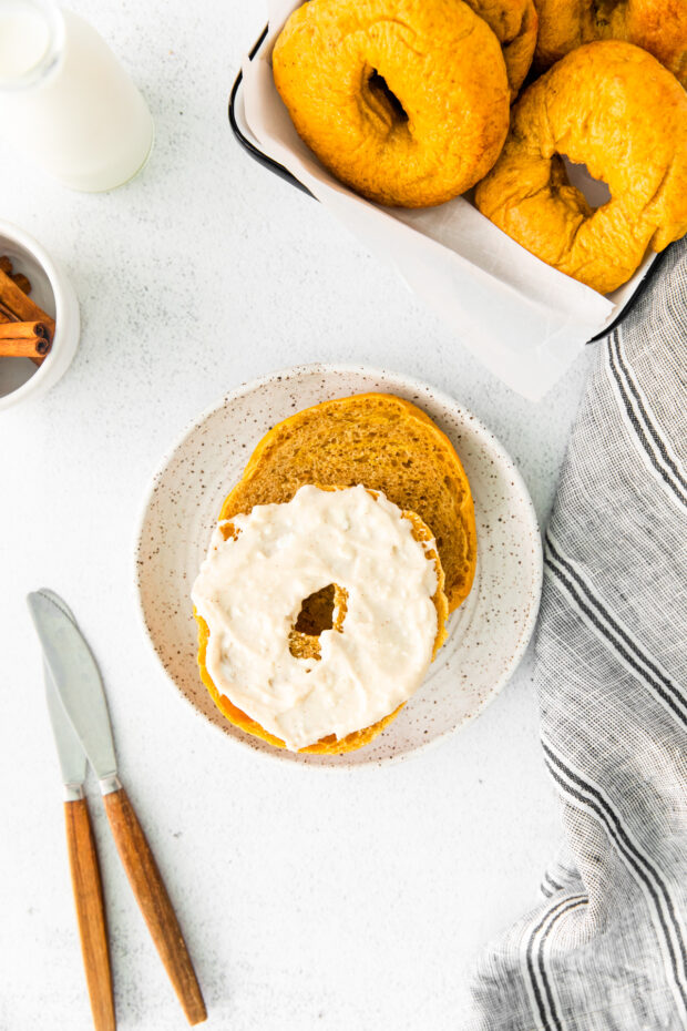 A bagel cut in half and spread with maple cream cheese.