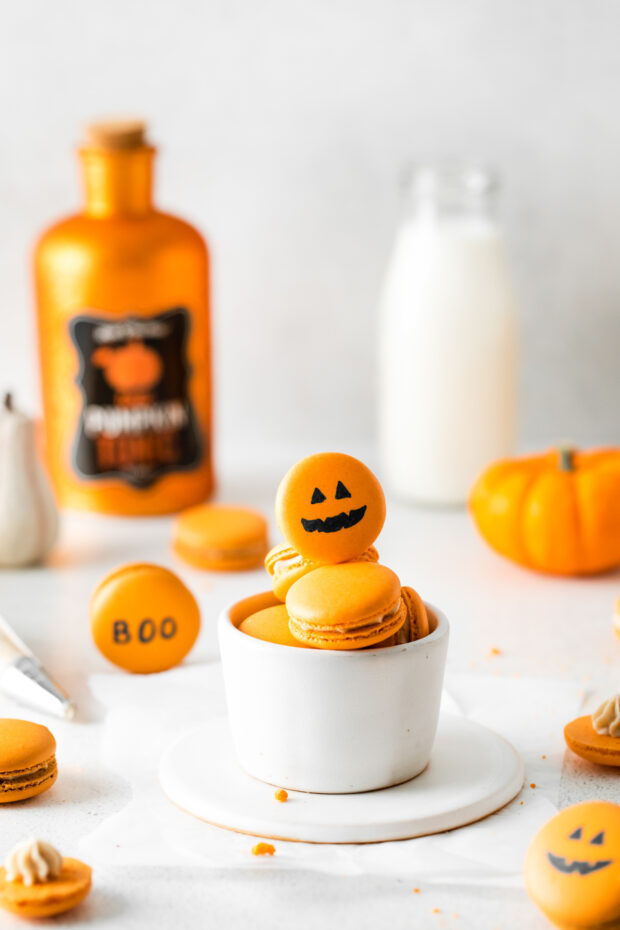 Pumpkin Spice Macarons designed to look like a carved pumpkin.