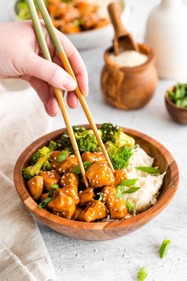 Instant Pot Teriyaki Chicken getting picked up with chopsticks. 