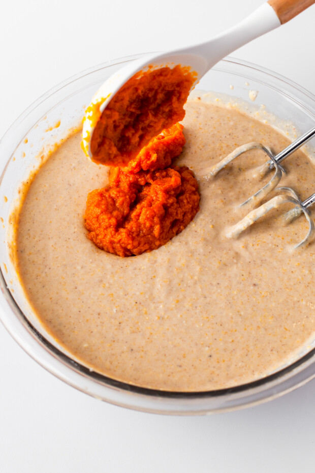 Adding pumpkin puree to the muffin batter. 