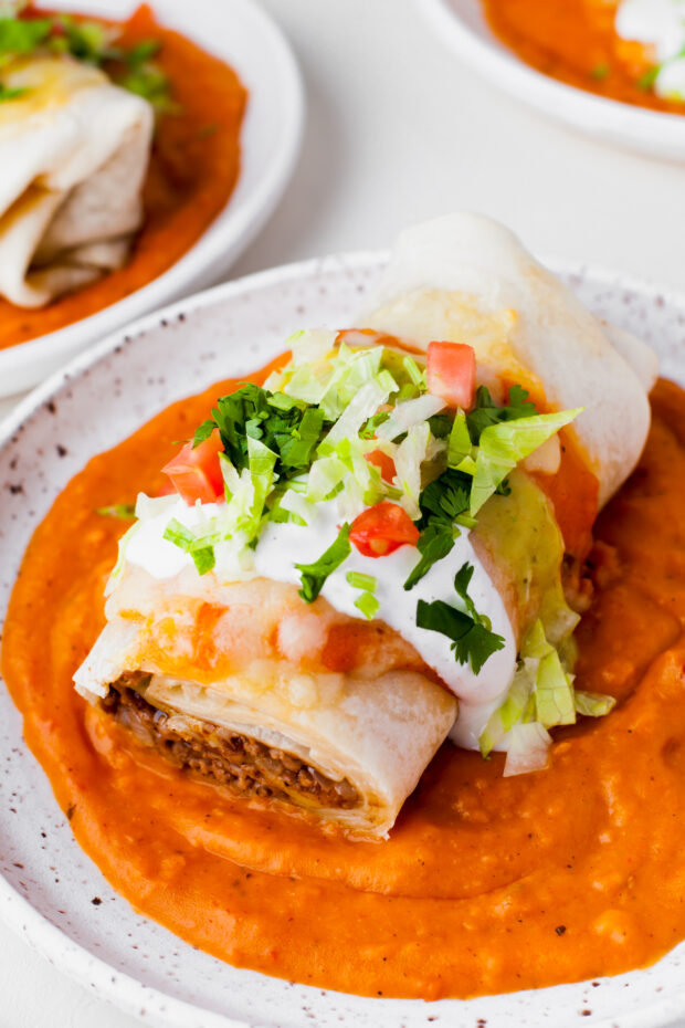 Smothered Burritos topped with sour cream, cheese, and lettuce. 