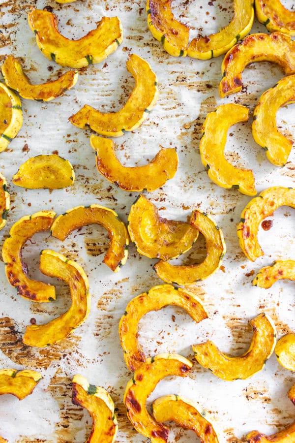 Cinnamon Maple Roasted Delicata  Squash on parchment paper. 