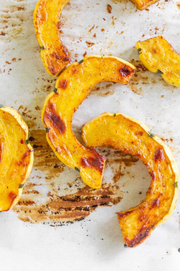 Cinnamon Maple Roasted Delicata squash on a sheet pan. 