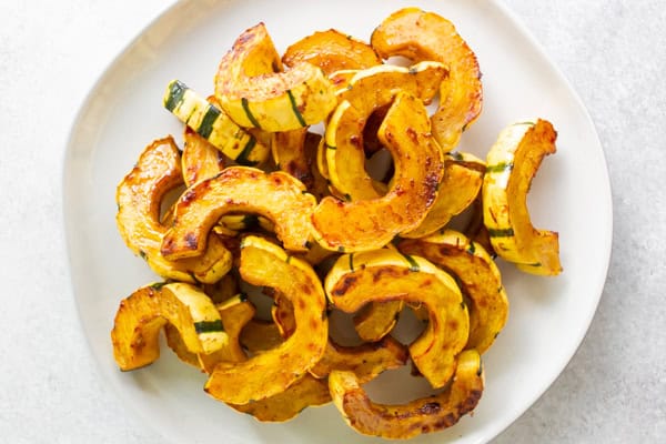 Cinnamon Maple Roasted Delicata Squash on a white serving plate. 