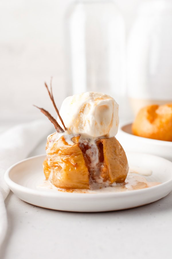 Cinnamon Baked Apples on a plate covered with ice cream. 
