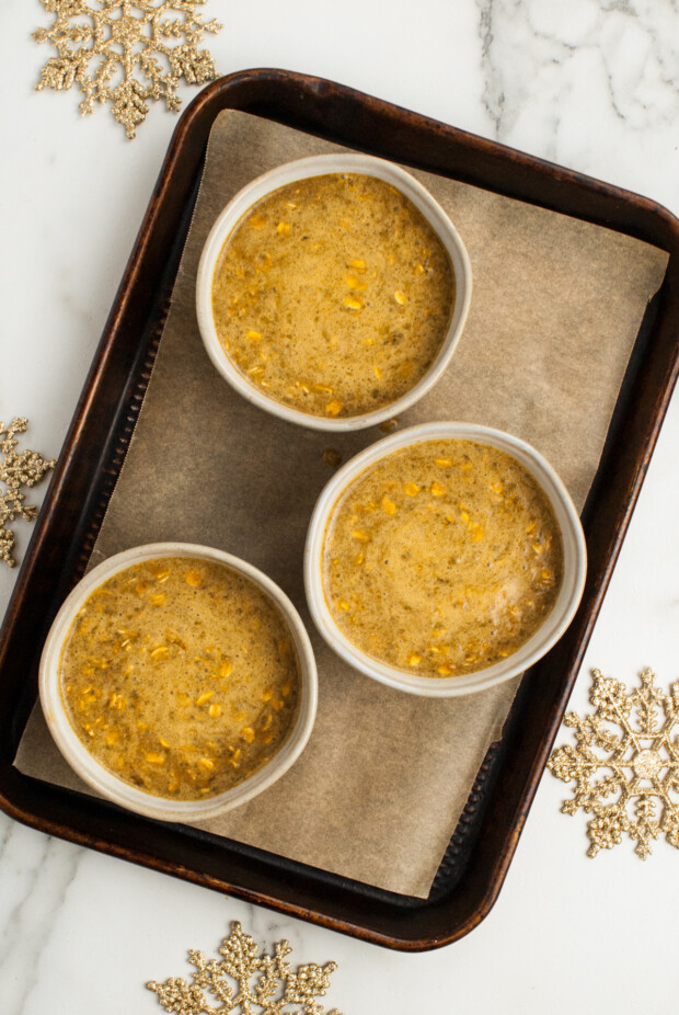 Unbaked Gingerbread Oatmeal in bowls on a sheet pan. 