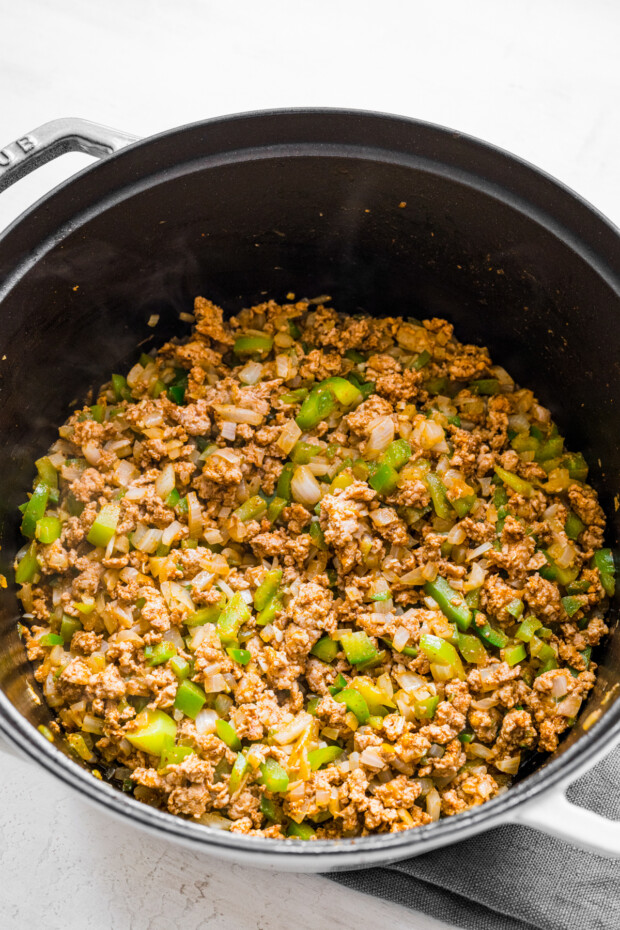 Ground turkey and vegetables in a pot for chili. 
