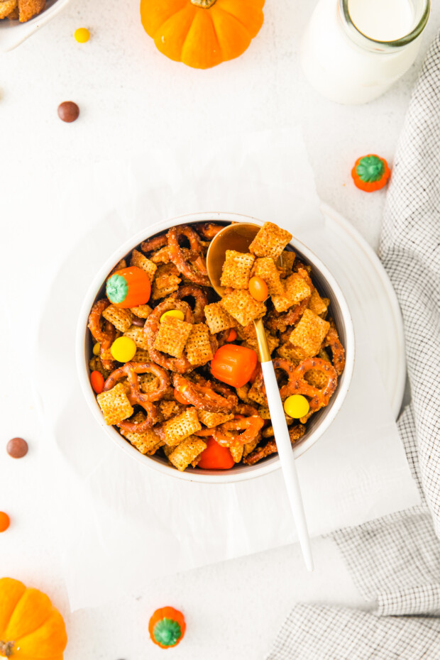 Harvest Chex Mix in a bowl with a spoon. 