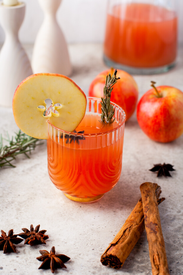 Instant Pot Apple Cider in a glass garnished with rosemary and apple. 
