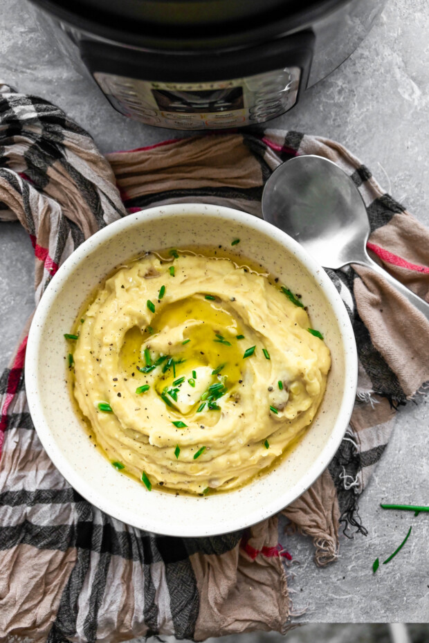 Instant Pot Mashed Potatoes in a white bowl with butter.