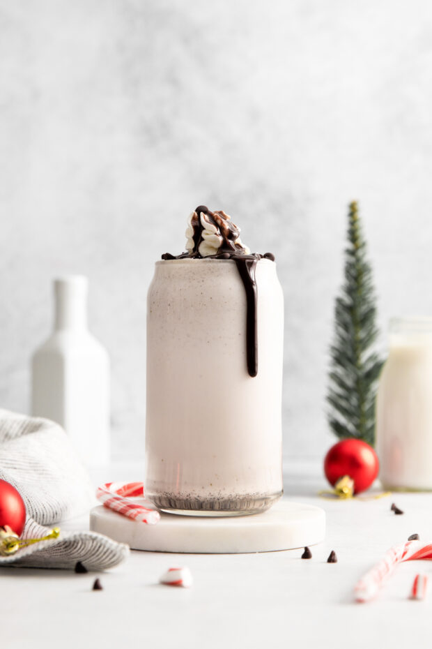 Peppermint Bark Milkshake in a glass with chocolate dripping down the side of the glass.