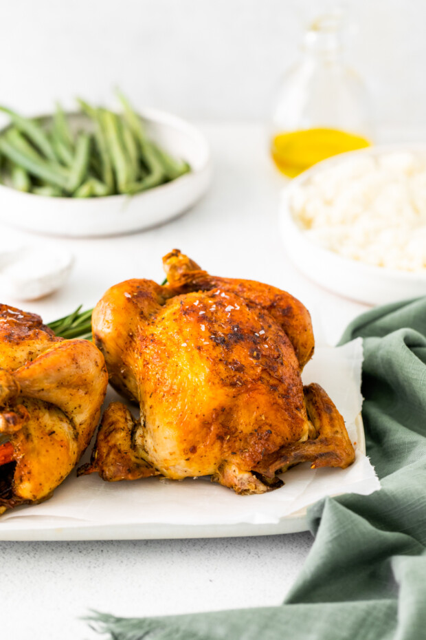 Roasted Cornish Hens on a white serving dish. 