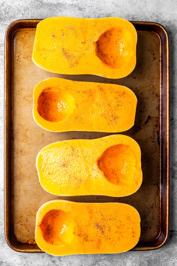 Halved butternut squash on a sheet pan. 
