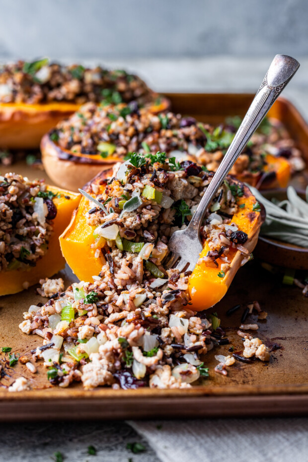 A fork scooping out a bite of Stuffed Butternut Squash. 