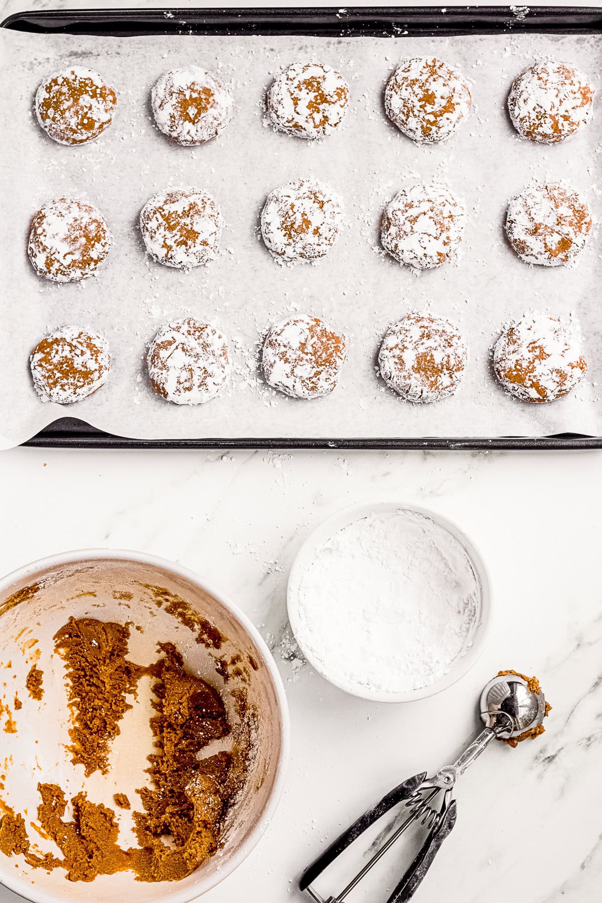 Molasses Crinkle Cookies scooped onto a baking sheet pan.