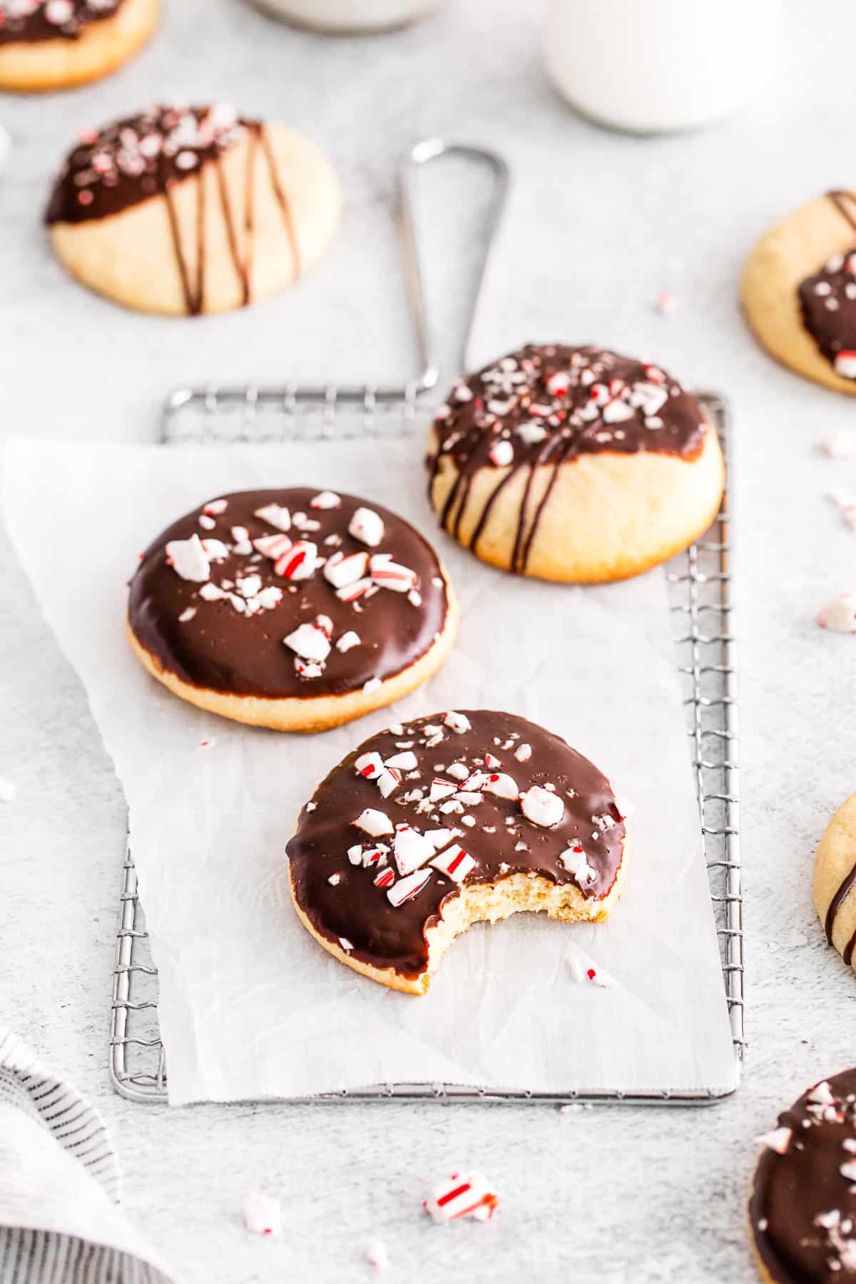 Peppermint Bark Shortbread Cookies on a table with a bite taken out of one of the cookies. 