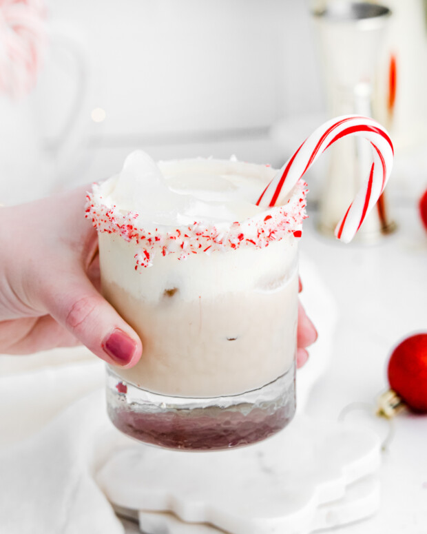 A hand holding a glass of Peppermint White Russian. 
