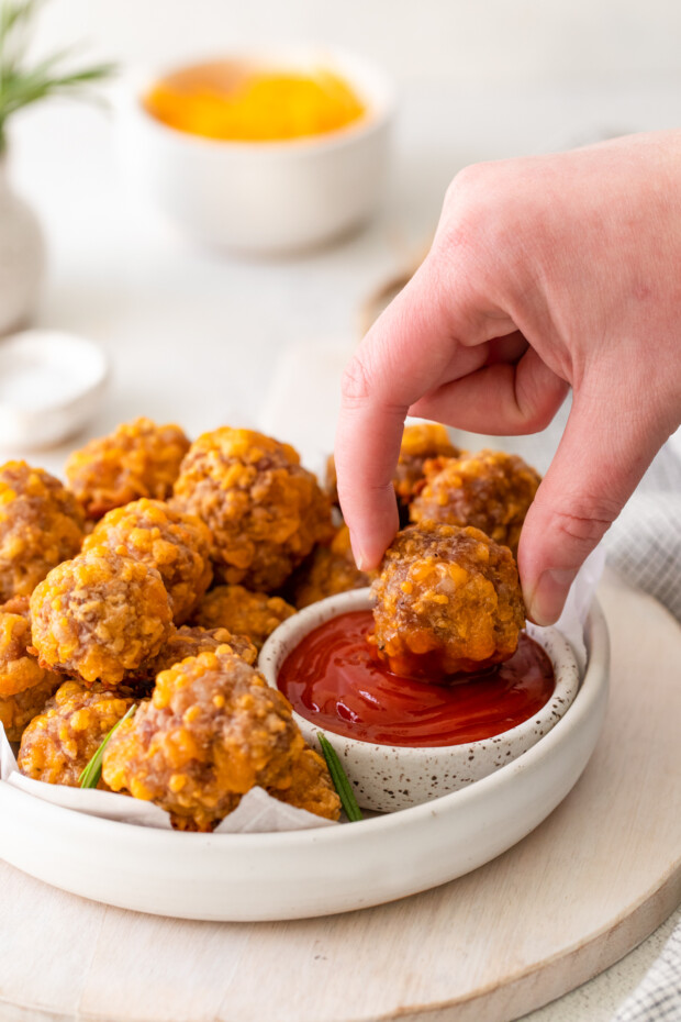 Sausage Cheese Balls being dipped into ketchup. 