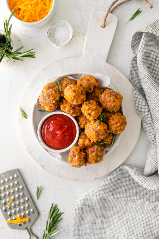 Sausage Cheese Balls in a bowl served on a wooden platter. 