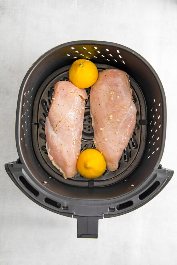 Uncooked Air Fryer Lemon Chicken in the air fryer basket. 