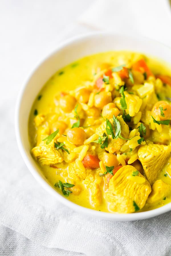 Chicken Coconut Milk Turmeric Soup served in a white bowl. 