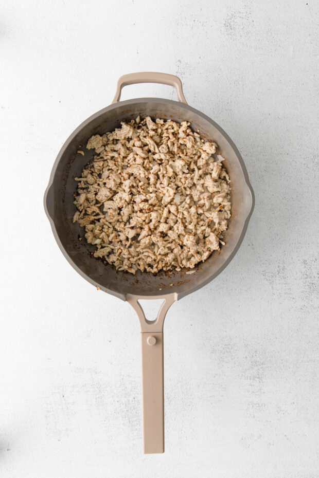 Ground chicken cooked in a skillet.
