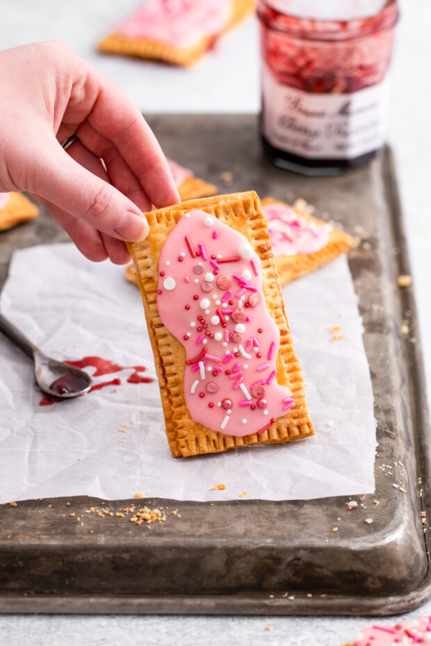Air Fryer Pop Tarts being held up by a hand. Air Fryer Pop Tarts