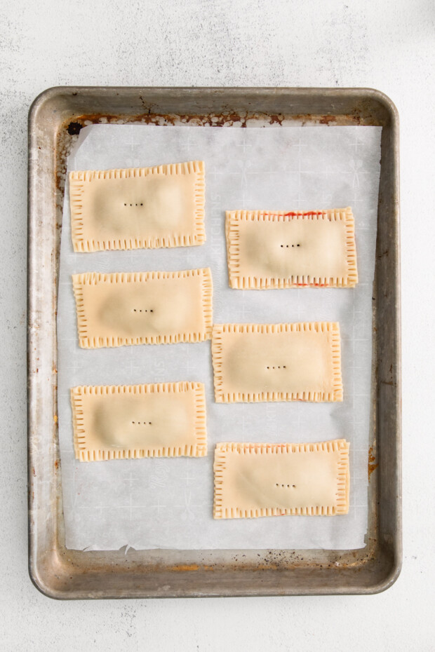 Homemade pop tarts uncooked on parchment paper. 