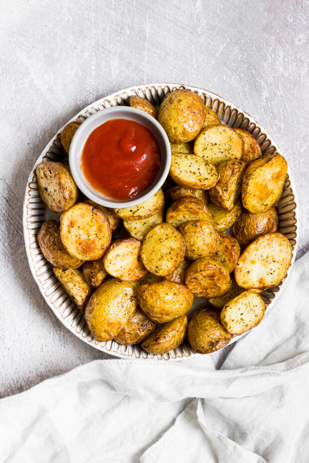 Air Fryer Roasted Potatoes on a plate with ketchup.