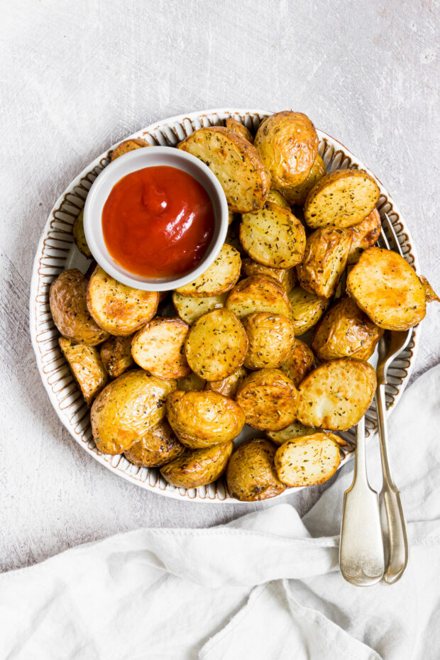 Air Fryer Roasted Potatoes on a plate with ketchup.