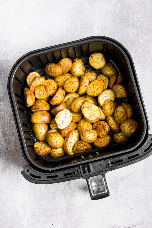 Air Fryer Roasted Potatoes sitting in an air fryer basket.