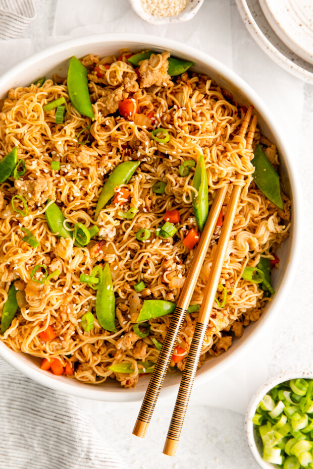 Ground Chicken Ramen Stir Fry served with sesame seeds and chopsticks. 