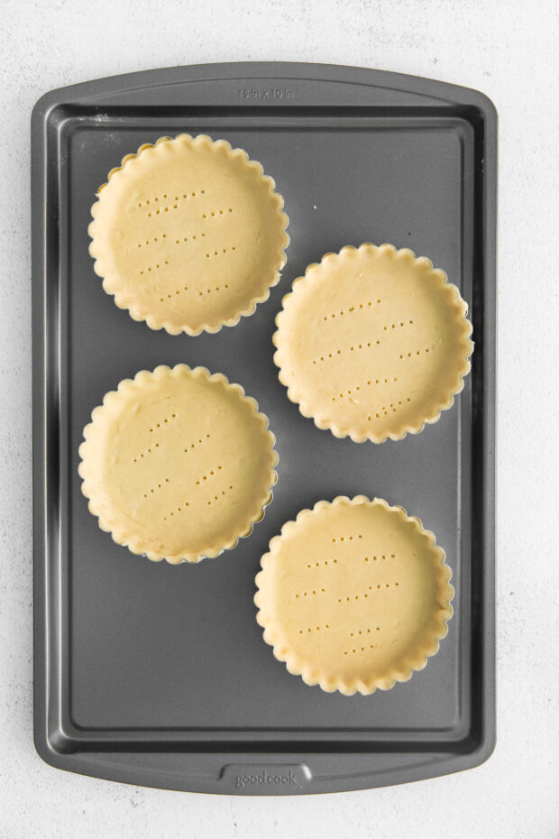Uncooked pie crust in mini tart pans.