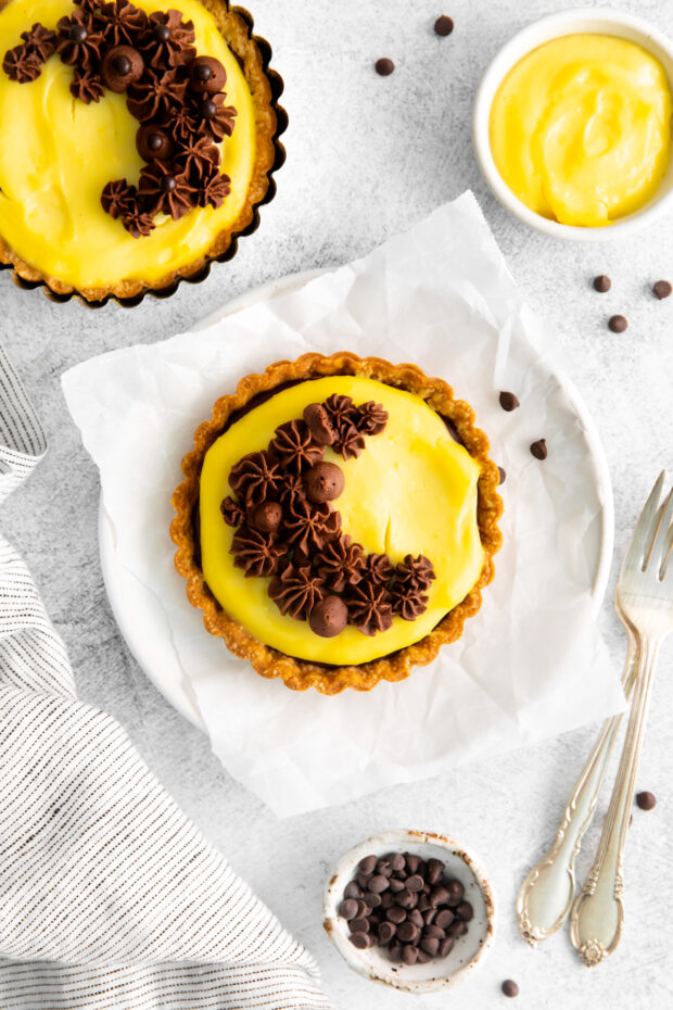 Boston Cream Pie Tarts decorated with chocolate frosting.