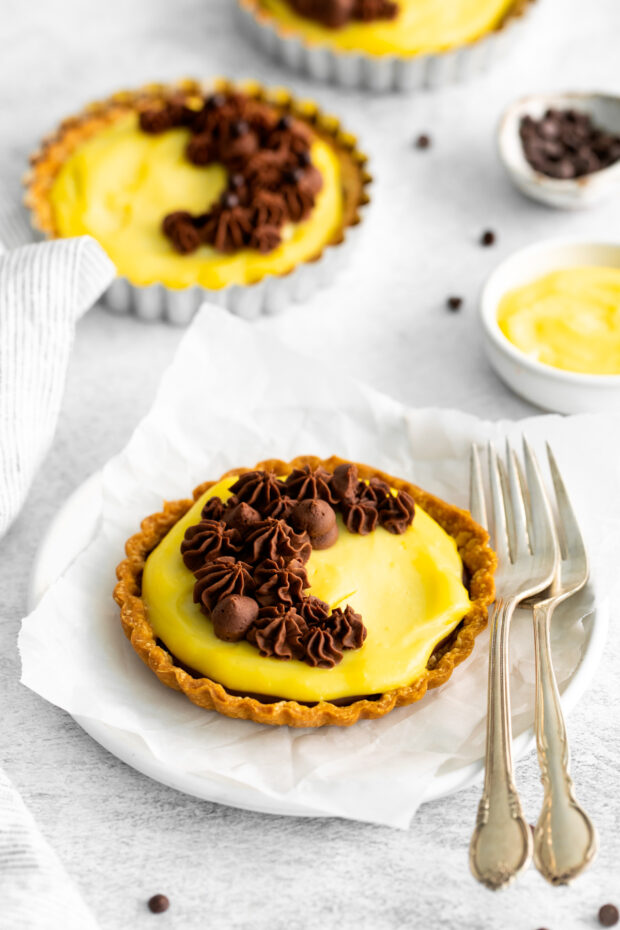 Boston Cream Pie Tarts sitting on a plate with forks.
