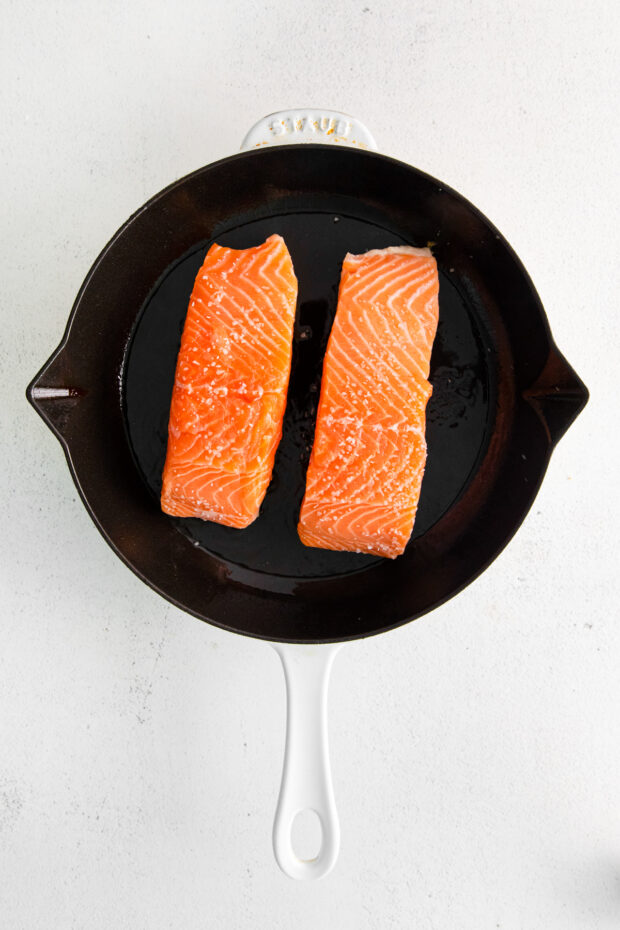 Salmon cooking in a skillet.