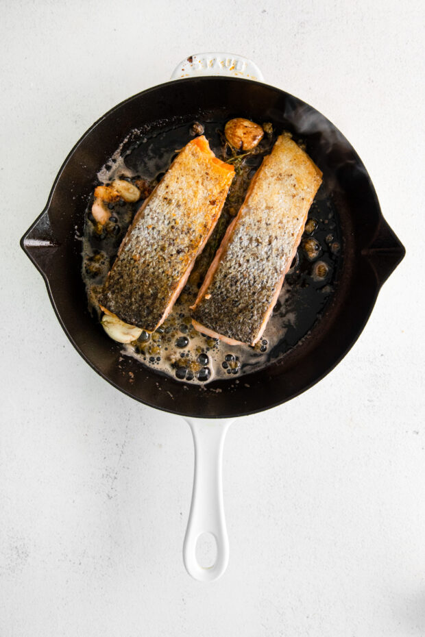 Salmon with crispy skin in a skillet.