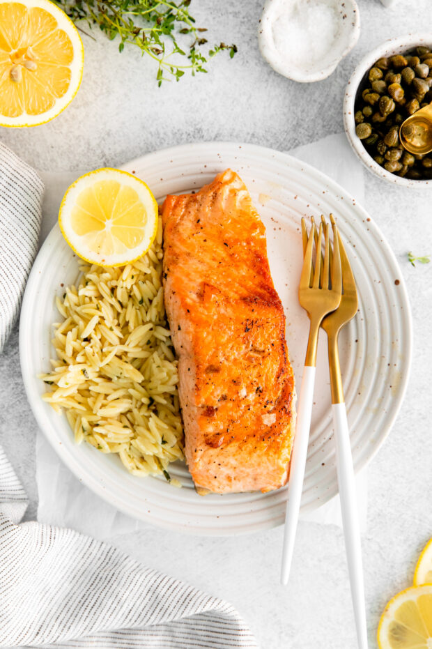 Pan Seared Salmon served with pasta and lemon.