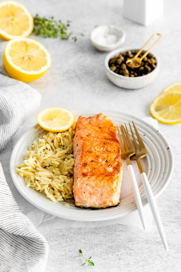 Pan Seared Salmon served with a fork on a white plate.