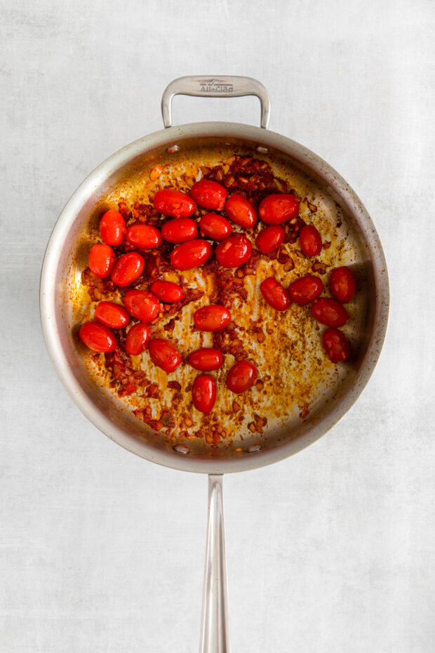 Cherry tomatoes and chili paste in a pan. 