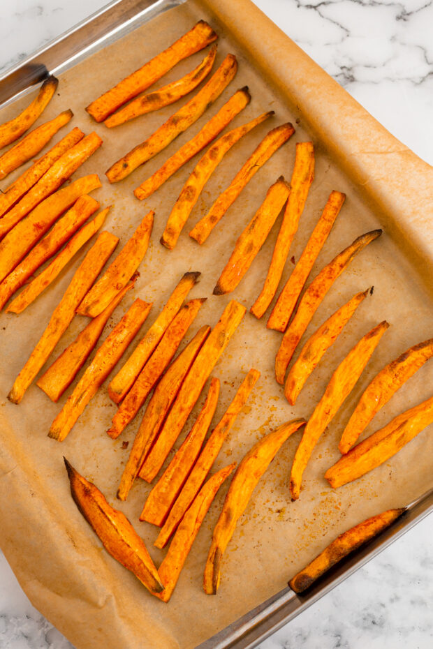 Cooked Sweet Potato Fries on a sheet pan. 