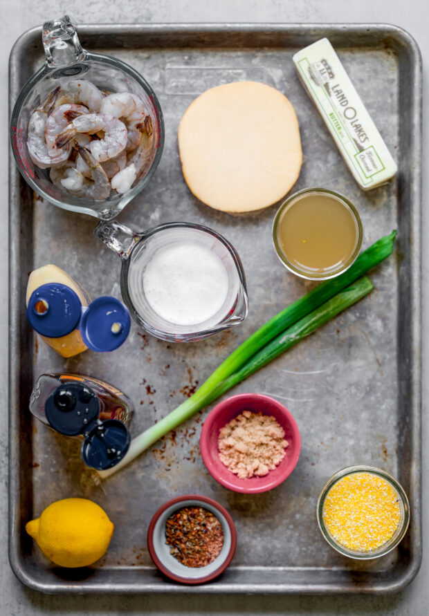 Ingredients to make Cajun Honey Butter Shrimp and Grits on a sheet pan.