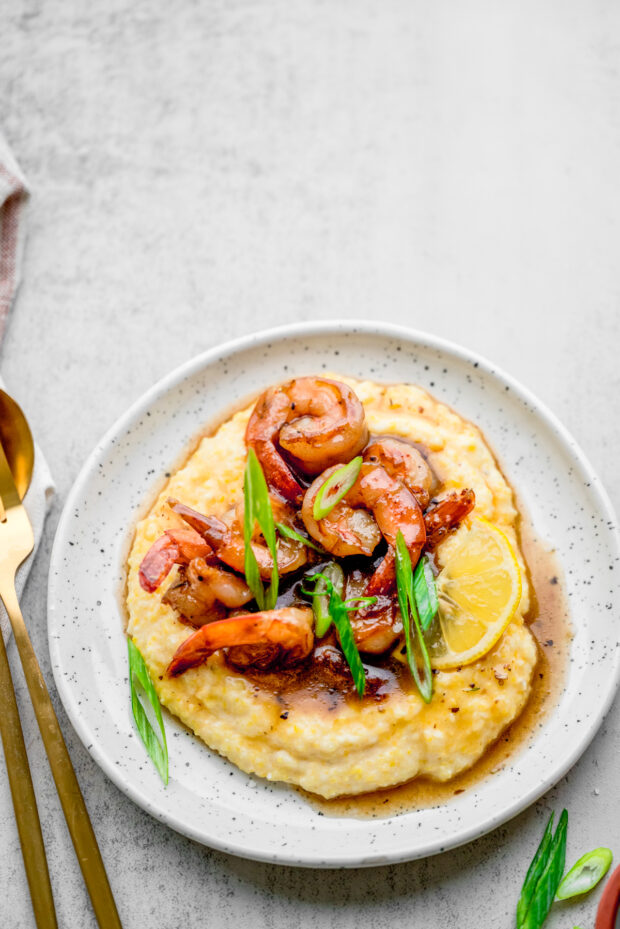 Cajun Honey Butter Shrimp and Grits served with extra sauce.