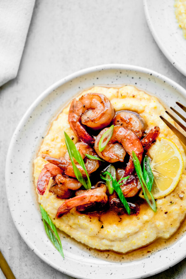 Cajun Honey Butter Shrimp and Grits topped with green onions.