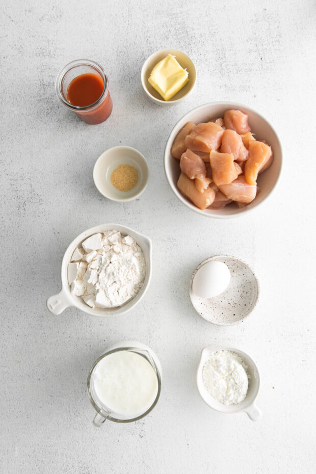 Ingredients to make Air Fryer Buffalo Chicken Nuggets sitting on a table. 