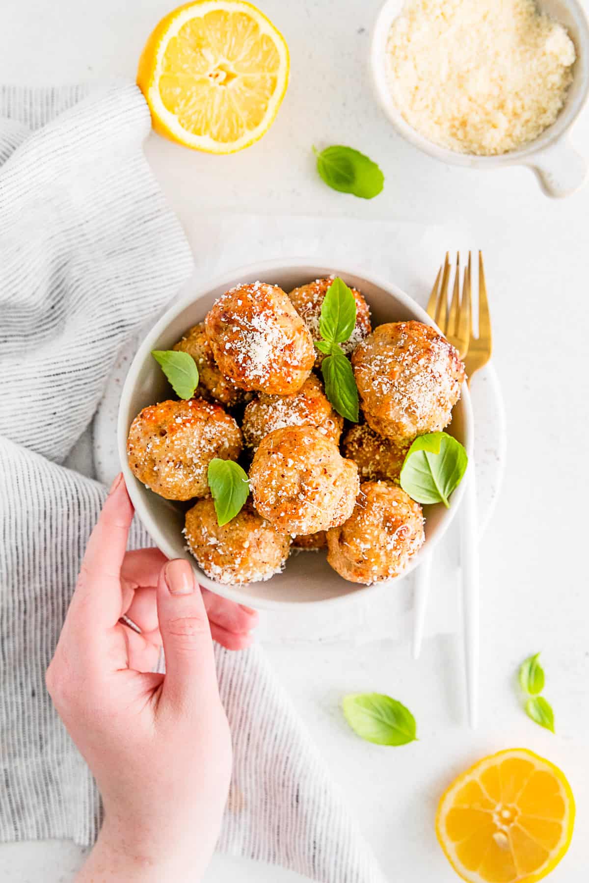 A bowl of Air Fryer Chicken Meatballs served with parmesan cheese. 
