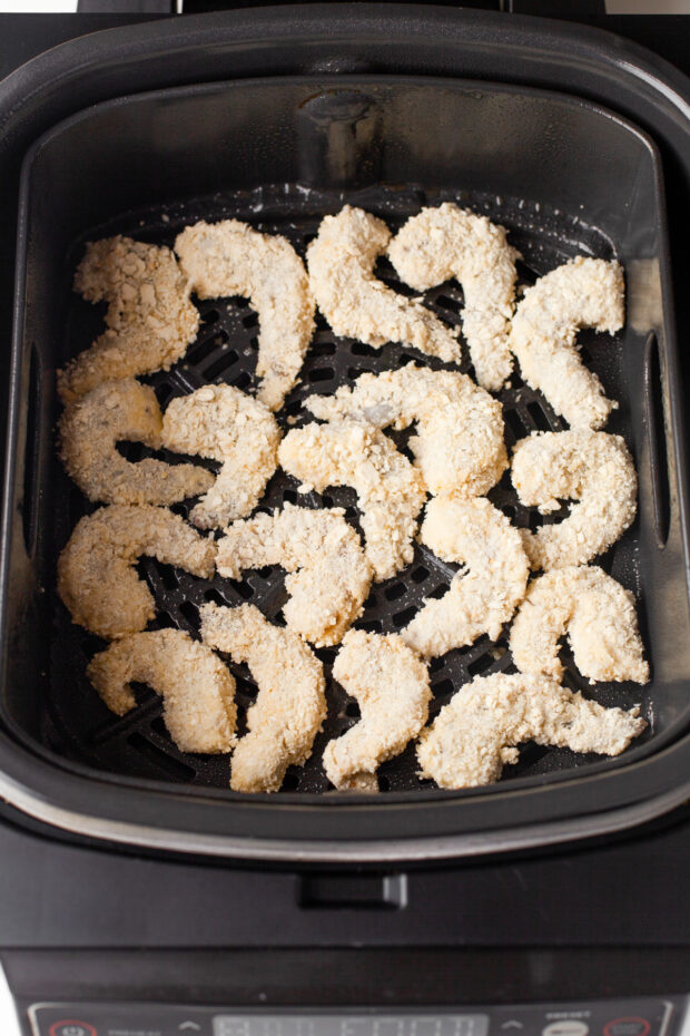 Breaded shrimp in an air fryer uncooked.