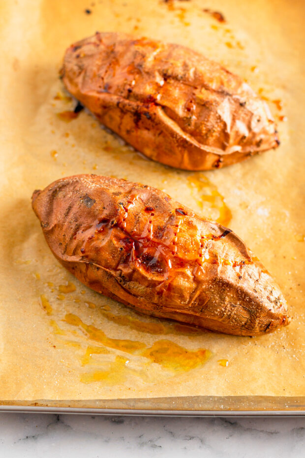 A baked sweet potato on parchment paper. 