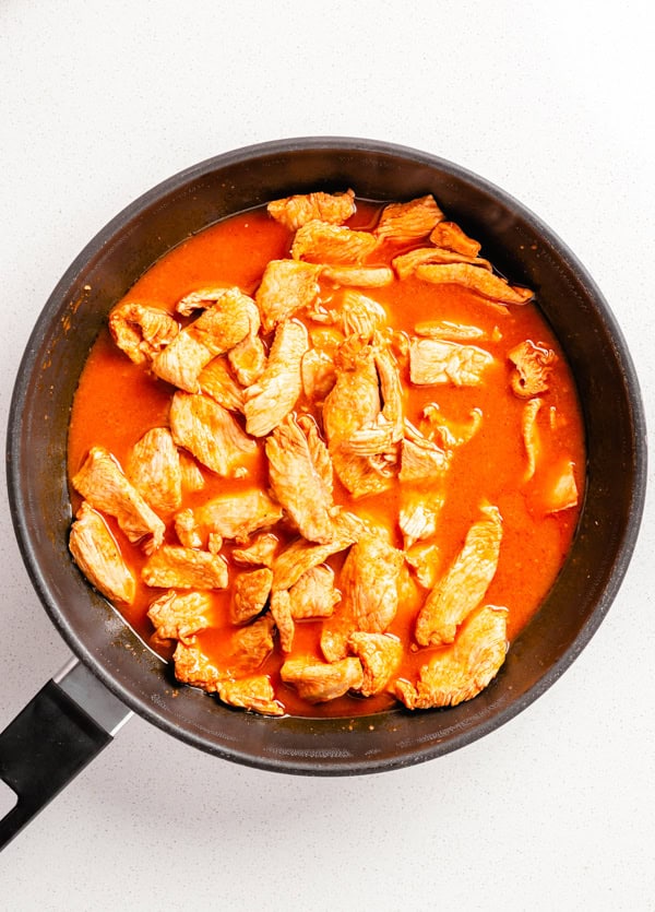 Chicken cooking in buffalo sauce marinade. 